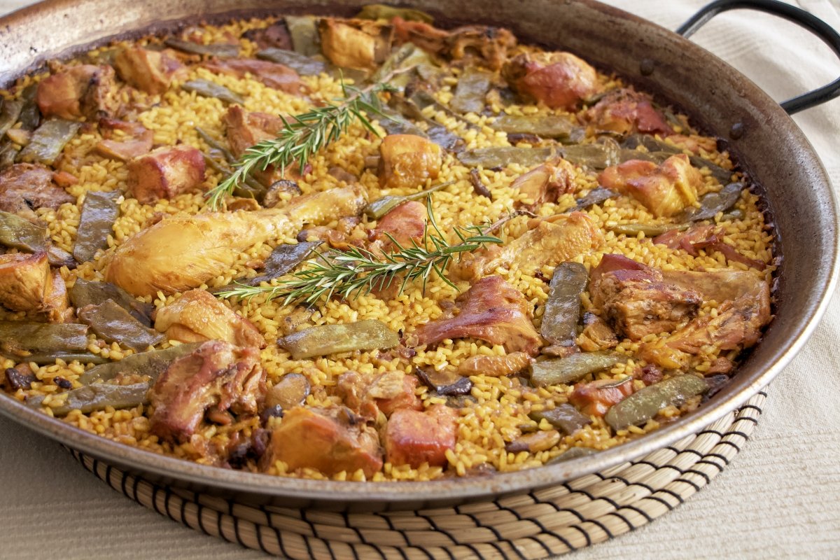 Paella valenciana tradicional con arroz, pollo, conejo, judía verde y romero